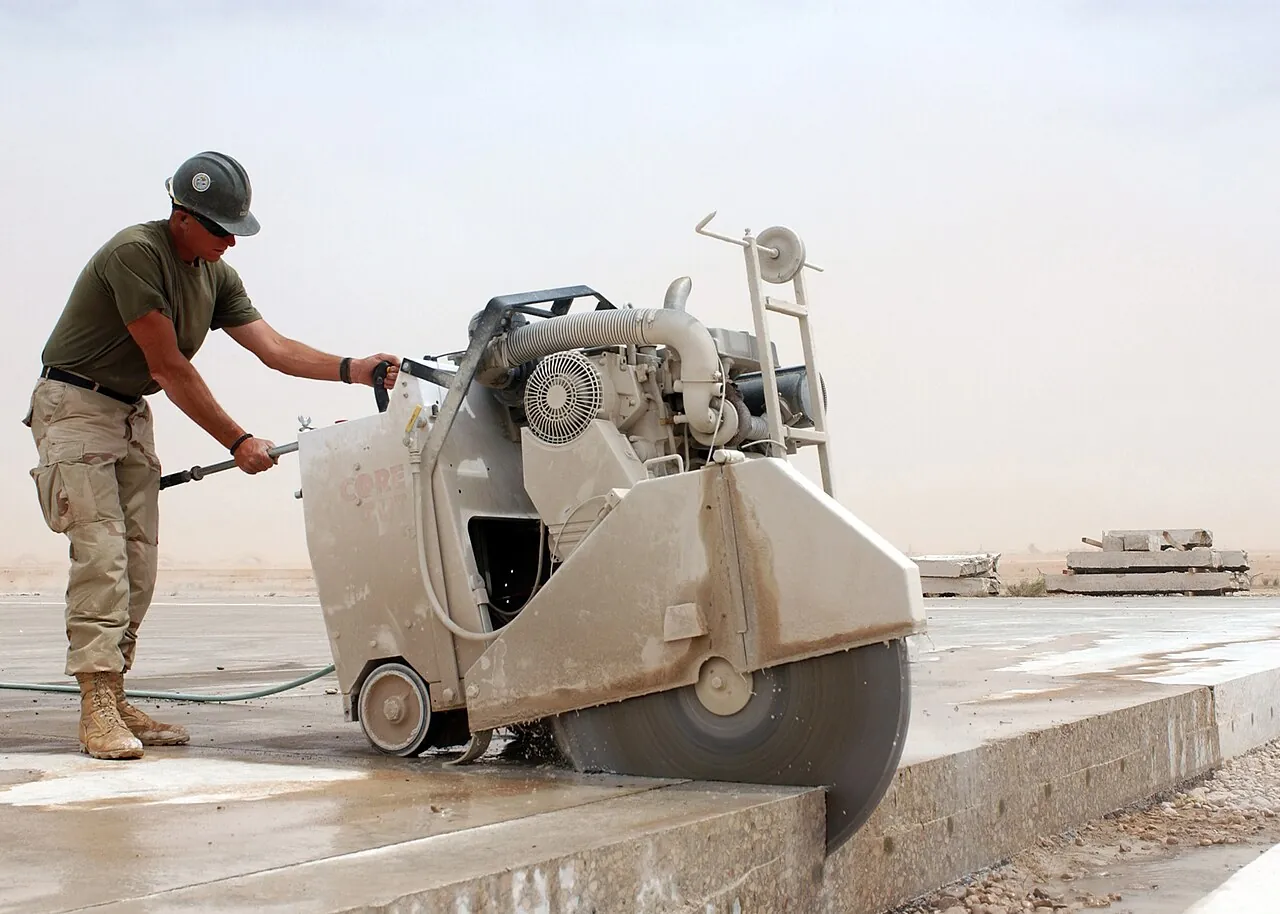 A walk-behind concrete saw cutting a slab